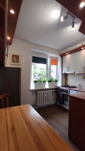 烏斯特卡的住宿－Apartament Baltic Ustka，厨房配有木桌和窗户。