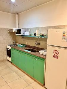 cocina con armarios verdes y nevera blanca en Mandalas 1, amplio apartamento en Belén de Escobar