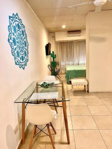 Habitación con mesa de cristal, sillas y cama en Mandalas 1, amplio apartamento en Belén de Escobar