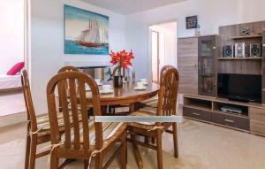 una sala da pranzo con tavolo, sedie e TV di Holiday home in Sevid 45752 a Sevid