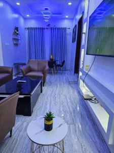 sala de estar con sofá y TV grande en HEN - CAP SERVICED APARTMETS en Agege