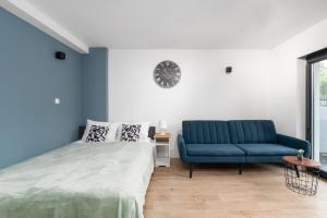 um quarto com uma cama e um sofá azul em Krośnieńska Studios on Ground Level by Renters em Poznań