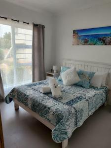Un dormitorio con una cama con almohadas y una ventana. en TimeOut 2, en Yzerfontein