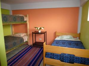a small room with two bunk beds and a table at Humberto Guest House in Huaraz