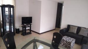 uma sala de estar com um sofá e uma televisão em APARTAMENTO VILLA OLÍMPICA em Pereira