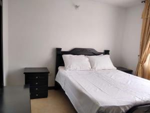 um quarto com uma cama e uma mesa de cabeceira ao lado em APARTAMENTO VILLA OLÍMPICA em Pereira