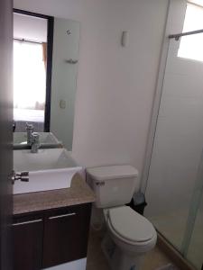 uma casa de banho com um WC branco e um lavatório. em APARTAMENTO VILLA OLÍMPICA em Pereira