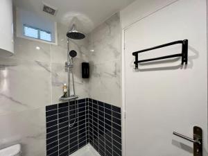 a bathroom with a shower with a toilet and a sink at Black Love-room - Balnéo - Cinéma in Souppes-sur-Loing
