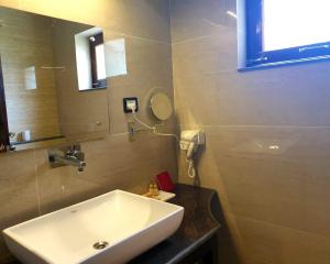 La Shayok Resort في نوبرا: حمام مع حوض أبيض ومرآة