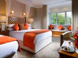 una camera d'albergo con due letti e una finestra di Dingle Benners Hotel a Dingle