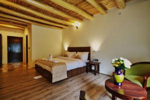 La Shayok Resort في نوبرا: غرفة نوم بسرير وطاولة في غرفة