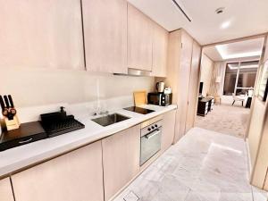 杜拜的住宿－Luxury Studio in High Floor Full Sea View in The Palm Tower Plam Jumeirah，白色的厨房设有水槽和炉灶。