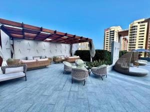 un patio avec des chaises et des tables en osier et un pavillon dans l'établissement Luxury Studio in High Floor Full Sea View in The Palm Tower Plam Jumeirah, à Dubaï