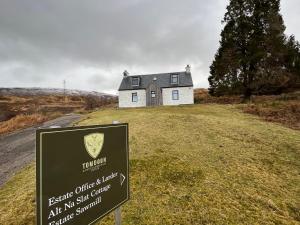 a house on a hill with a sign in front of it at Alt-Na-Slat Cottage in Invergarry