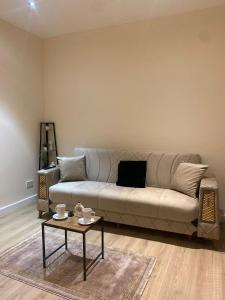 a living room with a couch and a coffee table at Queen's Cottage in Hendon