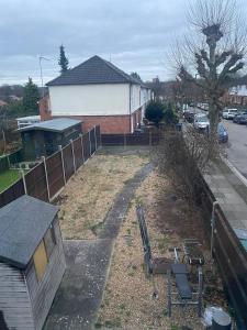 um quintal com uma cerca e um banco em frente a uma casa em Queen's Cottage em Hendon