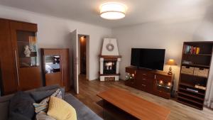 a living room with a couch and a flat screen tv at Apartament Baltic Ustka in Ustka