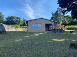 a small house in a yard with a grass field at When in the Middle Self Catering Guest House in Durban