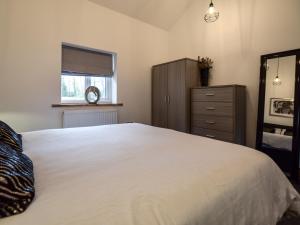 a bedroom with a large white bed and a dresser at 1 Bed in Malton 88457 