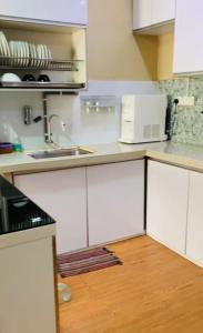 een keuken met witte kasten en een wastafel bij zam homestay kulim perdana hitech utk Msliim shj in Kulim