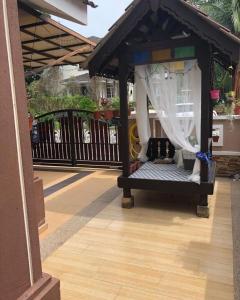 een prieel met een bed op een terras bij zam homestay kulim perdana hitech utk Msliim shj in Kulim