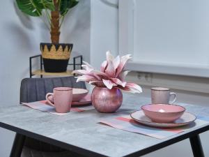 a table with plates and cups and a flower in a vase at Sleep1c in Hamburg +2 photos