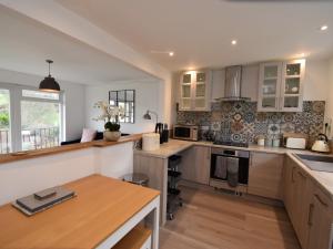 een keuken met witte kasten en een houten tafel bij 2 Bed in Lulworth Cove 79228 in West Lulworth