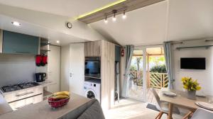 een keuken en een woonkamer met een tafel en een eetkamer bij Mobile-Home Le Mimosa Camping SIBLU**** in Fréjus