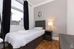 Un dormitorio con una cama con un reloj en la pared. en Pine House, en Stockton-on-Tees
