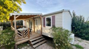 een tiny house met een veranda en een terras bij Mobile-Home Le Mimosa Camping SIBLU**** in Fréjus