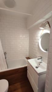 a white bathroom with a tub and a sink at Apartament Baltic Ustka in Ustka +37 photos