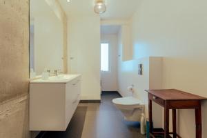 uma casa de banho com um lavatório branco e um WC. em Downtown - Retro Decor - Stunning Views - Terrace em Tórshavn