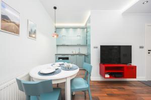 格但斯克的住宿－Krynicka 2 by Homeprime，一间带桌椅的厨房和一台电视