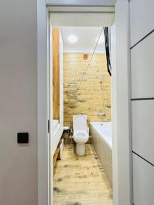 een badkamer met een toilet, een bad en een wastafel bij Apartaments COSTA ЖК Алпамыс in Astana