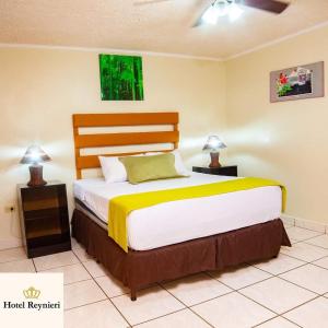 a bedroom with a large bed with two lamps at Hotel Reynieri in Comayagüela