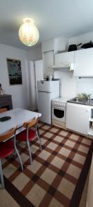 una cocina con electrodomésticos blancos y una mesa con sillas. en Agréable maison de ville proche centre ville en Nantes