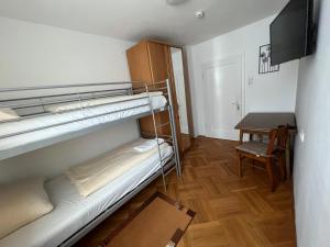 a small room with two bunk beds and a table at WG-Haus in Landshut