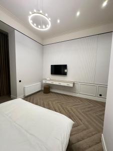 a white room with a bed and a flat screen tv at Five Hotel in Astana