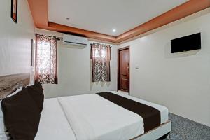 een slaapkamer met een bed en een flatscreen-tv bij OYO Sri Sai Sevalal Comfort's in Bangalore