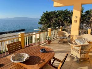 una terrazza in legno con tavolo, sedie e vista sull'oceano di Casa Alexandr Piedigrotta a Pizzo