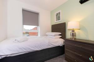 a bedroom with a bed with a dresser and a window at Wharf House TSAC in Stockton-on-Tees
