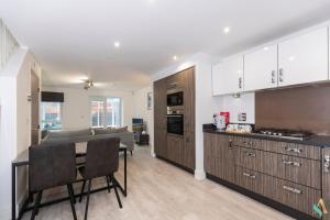a kitchen with wooden cabinets and a table and a dining room at Wharf House TSAC in Stockton-on-Tees
