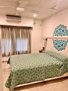 1 dormitorio con 1 cama con colcha verde en Mandalas 1, amplio apartamento en Belén de Escobar