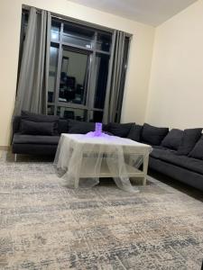 a living room with a table and a couch at Top House Hostel in Abu Dhabi