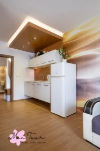 a kitchen with a white refrigerator in a room at Mon Tour apartments in Sunny Beach