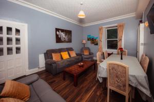 a living room with a couch and a table at Super Central 4bedroom Apartment at the Meadows in Edinburgh