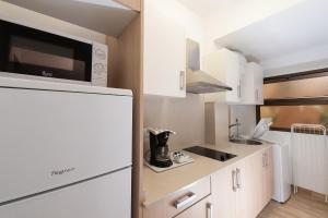 a kitchen with white cabinets and a refrigerator at Las Palmas Urban Center in Las Palmas de Gran Canaria