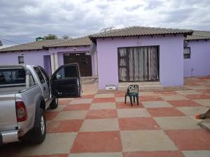 un coche aparcado frente a una casa púrpura en Tsoga Odire guest House, en Ledig