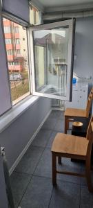 a room with two windows and a table and a chair at Feel Like Home 2 in Piatra Neamţ