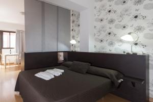 1 dormitorio con 1 cama con 2 toallas en Las Palmas Urban Center, en Las Palmas de Gran Canaria
